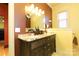 Bathroom with dark wood cabinets, marble countertop, decorative mirror and sconce lighting at 1001 Parkwood Ave, Charlotte, NC 28205