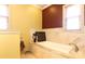 Bright bathroom boasts a soaking tub with travertine tile surround and a large window for natural light at 1001 Parkwood Ave, Charlotte, NC 28205