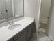 Bathroom features a gray vanity, white sink, modern faucet, toilet, and a shower with glass doors at 1005 Cherry Laurel Dr, Waxhaw, NC 28173