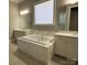 Bathroom featuring a soaking tub with marble surround and vanities with dual sinks and modern fixtures at 1005 Cherry Laurel Dr, Waxhaw, NC 28173