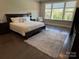 Bright bedroom featuring a large bed, wood floors, a rug, and ample natural light from the large windows at 1005 Cherry Laurel Dr, Waxhaw, NC 28173