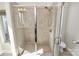 Tiled shower with glass doors, tile flooring, and a low-flow toilet in a naturally lit bathroom at 1037 Pierre Dr, Charlotte, NC 28205