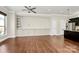 Spacious living room featuring hardwood floors, ceiling fan and custom built-in cabinets at 1037 Pierre Dr, Charlotte, NC 28205