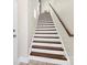 Staircase with hardwood treads and white risers, complemented by a stained wood handrail at 1037 Pierre Dr, Charlotte, NC 28205