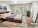 Cozy bedroom with large windows, plush carpet, and stylish wood furniture at 1269 E Woodlawn Rd, Charlotte, NC 28209