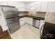 View of the kitchen with stainless steel refrigerator, granite countertops and white cabinetry at 1269 E Woodlawn Rd, Charlotte, NC 28209