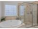 Relaxing bathroom featuring a soaking tub, a glass enclosed shower, and a large window at 13500 Robert Walker Dr, Davidson, NC 28036