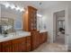 Bathroom showcasing dual vanities with wood cabinetry, framed mirrors, and a separate water closet at 13500 Robert Walker Dr, Davidson, NC 28036