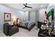 Comfortable bedroom with a dark wood bed frame, ceiling fan, and grey easy chair at 13500 Robert Walker Dr, Davidson, NC 28036