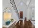 Elegant foyer with hardwood floors, a curved staircase, and a decorative mirror creating a grand entrance at 13500 Robert Walker Dr, Davidson, NC 28036