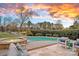 Outdoor pool and hot tub, surrounded by a well-manicured lawn and patio seating area under a colorful sky at 13500 Robert Walker Dr, Davidson, NC 28036