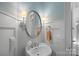 Charming powder room featuring designer wallpaper, a pedestal sink, and elegant lighting fixtures at 13500 Robert Walker Dr, Davidson, NC 28036