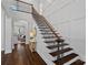 Grand staircase with dark wood steps and wrought iron railing, complemented by light walls and hardwood flooring at 13500 Robert Walker Dr, Davidson, NC 28036