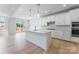 Modern white kitchen features an island with pendant lighting and stainless steel appliances at 136 Glenn Dr, Mooresville, NC 28115