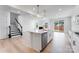 Open kitchen with island, stainless steel appliances, and adjacent living area with a fireplace at 136 Glenn Dr, Mooresville, NC 28115
