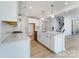 Contemporary white kitchen with an island, stainless steel appliances, and light wood flooring at 136 Glenn Dr, Mooresville, NC 28115