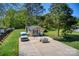 Backyard view, showcasing a well-maintained lawn, multiple sheds, and a van parked on the concrete at 1532 South Point Rd, Belmont, NC 28012