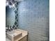 Bathroom with blue subway tile backsplash, a round mirror, and vanity sink at 1532 South Point Rd, Belmont, NC 28012