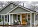 View of the home's front porch with wooden door and charming decorations at 1532 South Point Rd, Belmont, NC 28012