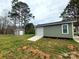 View of a gray building with a roll-up garage door and a cement ramp and small shed in the background at 1532 South Point Rd, Belmont, NC 28012