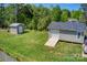 A backyard with 2 sheds, with lush greenery and part of a vehicle shown on the side at 1532 South Point Rd, Belmont, NC 28012