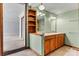 Bathroom with double sinks, wood cabinets, and vintage light fixtures at 156 Hazelton Loop, Mooresville, NC 28117