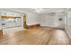 Bright living room showcasing hardwood floors and an attached kitchen with white appliances and light walls at 156 Hazelton Loop, Mooresville, NC 28117