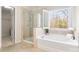 Bright bathroom featuring a separate shower and tub with plantation shutters at 2000 Willowcrest Dr, Waxhaw, NC 28173