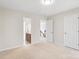 Bright bedroom featuring a carpeted floor, ensuite bathroom and view of the stairs at 2000 Willowcrest Dr, Waxhaw, NC 28173
