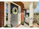 Welcoming front door with a decorative wreath, sidelights, and charming porch seating at 2000 Willowcrest Dr, Waxhaw, NC 28173