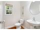 Bright powder room featuring hardwood floors, decorative wall art, and a window that offers natural light at 2000 Willowcrest Dr, Waxhaw, NC 28173