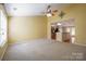 Spacious carpeted living room with high ceilings, a fan, and an open layout to the kitchen at 2007 Wexford Way, Statesville, NC 28625