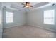 A large bedroom with tray ceiling, carpet flooring, and ample natural light at 2007 Wexford Way, Statesville, NC 28625