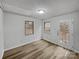 Bedroom featuring vinyl floors, two windows, and an exterior door for backyard access at 2015 Springfield Ct, Gastonia, NC 28052