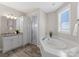 Elegant bathroom features a soaking tub, walk-in shower, and modern vanity with storage at 21013 Island Forest Dr, Cornelius, NC 28031