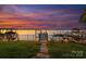 Waterfront property featuring a private dock with boat slips and stunning sunset views over the lake at 21013 Island Forest Dr, Cornelius, NC 28031