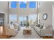 Bright living room with soaring ceilings, large windows, and lake views at 21013 Island Forest Dr, Cornelius, NC 28031