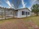 Backyard view with a wooden pergola, and a white house with black shutters at 211 9Th St, Belmont, NC 28012