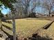 Expansive backyard showcasing a large grassy area, bordered by a classic wooden fence, perfect for outdoor activities at 211 9Th St, Belmont, NC 28012