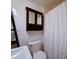 Bathroom with floral-themed wallpaper, mirror, and a white shower curtain at 211 9Th St, Belmont, NC 28012