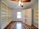 This bedroom features hardwood floors, a ceiling fan, bright white built in shelving, and sliding mirror door closet at 211 9Th St, Belmont, NC 28012
