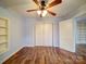 Bedroom featuring light blue walls, ceiling fan, double closet and wood look flooring at 211 9Th St, Belmont, NC 28012