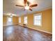 Bright living room with hardwood floors, three windows, ceiling fan, and white trim accents at 211 9Th St, Belmont, NC 28012