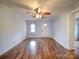 Inviting living room featuring wood-look floors, ceiling fan, and a white front door at 211 9Th St, Belmont, NC 28012