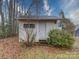 Backyard shed with a weathered door and surrounding bushes at 211 9Th St, Belmont, NC 28012