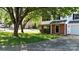 Charming two-story home featuring a brick facade, green lawn and mature tree at 303 Cupped Oak Ct, Charlotte, NC 28213