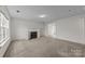Living room with a fireplace, light colored carpet, and large window at 303 Cupped Oak Ct, Charlotte, NC 28213
