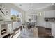 Sunlit dining room featuring dark wood floors, white cabinets, and modern chandelier at 305 Kentmere Ln, Clover, SC 29710