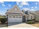 Charming home with a two-car garage, manicured landscaping, and a welcoming front porch under a blue, cloudy sky at 305 Kentmere Ln, Clover, SC 29710