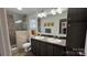 Bathroom features dual sinks, a spacious mirror, decorative light fixtures, and a tiled shower at 312 Sailwinds Rd, Mooresville, NC 28115